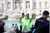 Woman in front of fountain taking selfie