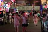 Two young Asian woman walking along a busy street.